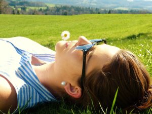 Schluss mit Keine zeit fuer mich - Frau liegt auf der Wiese in der Sonne